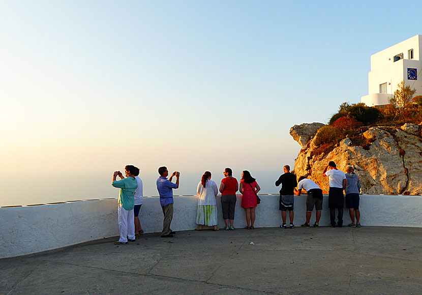 Förväntansfulla turister vid Pounta Square som väntar på solnedgången på Folegandros i Grekland.