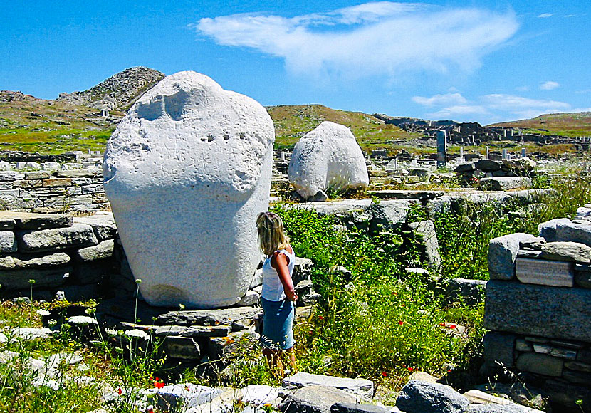 Rester av antika statyer med gigantiska torso på Delos nära Mykonos.